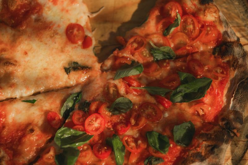 Margherita thin crust pizza with fresh tomato and basil