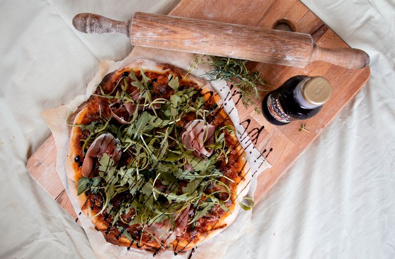 Prosciutto arugula thin crust pizza with parmesan shavings